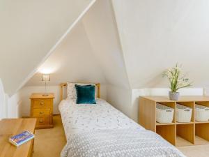 a small bedroom with a bed and a table at Yew Tree Farm in Charing