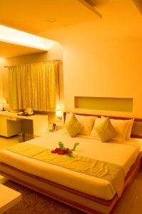 Un dormitorio con una cama grande con una flor. en GOLDEN LEAF RESORT, en Surajgarha