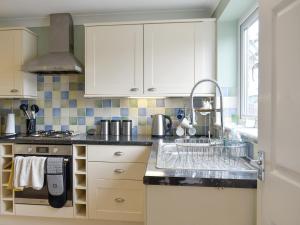 a kitchen with white cabinets and a sink at Archers Retreat in Greenhill