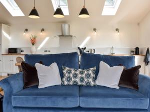 a blue couch with pillows on it in a living room at Birkshaw Barn in Bardon Mill