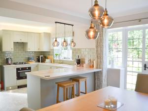 a kitchen with white cabinets and a table with chairs at Silcrest in Baslow