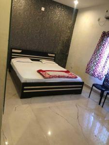 una camera con letto e sedia di OYO Flagship The Hunger Bite Resort a Bodh Gaya