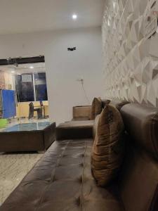 un divano in pelle marrone in soggiorno di OYO Flagship The Hunger Bite Resort a Bodh Gaya