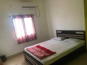 una camera da letto con un grande letto e una finestra di OYO Flagship The Hunger Bite Resort a Bodh Gaya