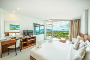a hotel room with a bed and a desk and a window at The View Rawada Phuket in Rawai Beach