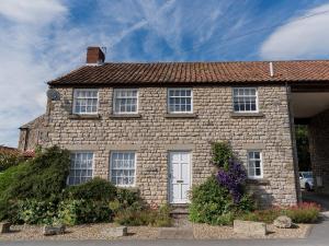 a large brick house with a white door at Levisham in Pickering