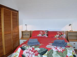 sypialnia z czerwonym łóżkiem i 2 niebieskimi ręcznikami w obiekcie Ingleside w mieście Ballantrae