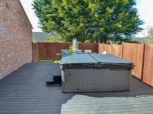 a patio with a table with a roof on a deck at The Farmhouse in Cromer