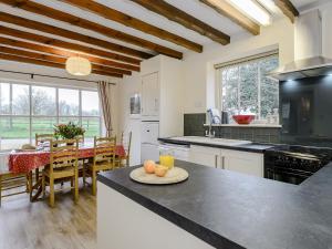 a kitchen and dining room with a table with oranges on the counter at The Old Saddlery in Colkirk