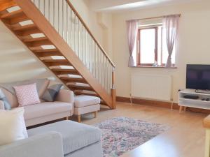 a living room with a staircase and a couch at Marina Retreat in Milford Haven