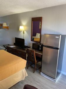 a hotel room with a desk and a refrigerator at Budget Host Inn in Greenup