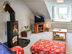 a living room with a fireplace and a tv at The Old Toll House in Portpatrick
