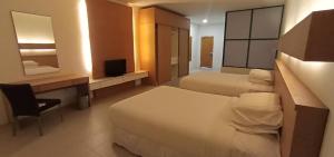 una camera d'albergo con 2 letti, una scrivania e una TV di Ara Hotel a Bau