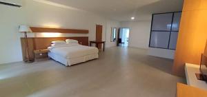 una camera con letto bianco e TV di Ara Hotel a Bau