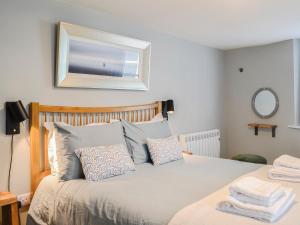 una camera da letto con letto, cuscini blu e specchio di The Old Toll House a Portpatrick