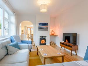 a living room with a couch and a table and a fireplace at Beach Holme in East Wittering