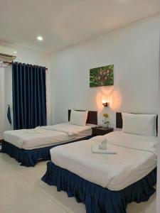 una habitación de hotel con 2 camas en una habitación en SUBINH HOTEL AND RESTAURANT en Pakse