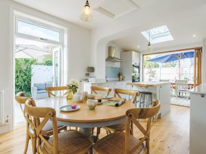 a kitchen and dining room with a wooden table and chairs at Beach Holme in East Wittering