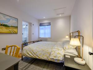 a bedroom with a bed and a table with a lamp at Beach Holme in East Wittering