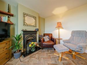 a living room with a fireplace and two chairs and a television at Valley View in Malvern Wells