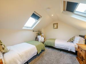 a attic bedroom with two beds and two windows at Valley View in Malvern Wells