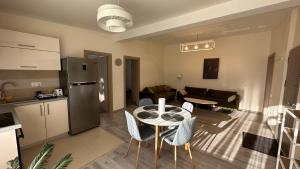cocina y sala de estar con mesa y sillas. en Aso Green ApartHotel Cluj Napoca en Cluj-Napoca