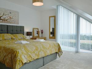 a bedroom with a large bed and a large window at The Steading in Dubton