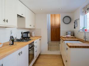 a kitchen with white cabinets and wooden counter tops at Loreto in Freshwater