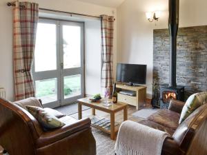 a living room with a couch and a fireplace at Stanegate Cottage in Greenhead