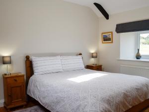 1 dormitorio con cama blanca y ventana en Stanegate Cottage en Greenhead