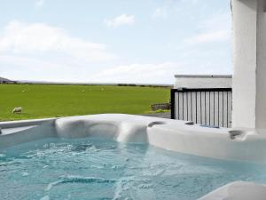 a hot tub with a view of a field at Stinchar View in Ballantrae