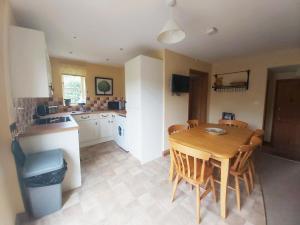 eine Küche und ein Esszimmer mit einem Holztisch und Stühlen in der Unterkunft Carrot Cottage - Uk32609 in Manton