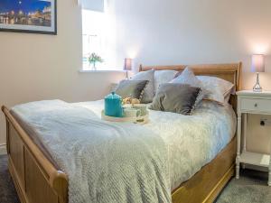 un letto con un vassoio con una tazza sopra di Heron Apartment a Berwick-Upon-Tweed