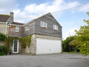 una casa con un garaje blanco en Purbeck Apartment, en Chideock