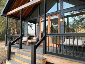 une maison noire avec des portes en verre et une terrasse dans l'établissement Relaxing Modern stay on a Ranch, à Cedar Creek