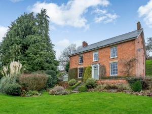 une vieille maison en briques avec une cour verdoyante dans l'établissement Old Upper Gwestydd, à Highgate