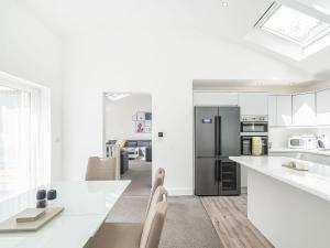a kitchen with white counters and a black refrigerator at High Trees View in Knaresborough