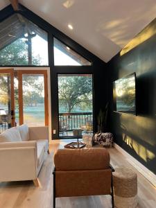 - un salon avec un canapé, des chaises et des fenêtres dans l'établissement Relaxing Modern stay on a Ranch, à Cedar Creek