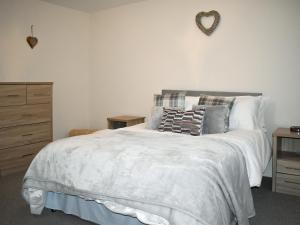 a bedroom with a white bed with a heart on the wall at Mountain View in Blaenau-Ffestiniog