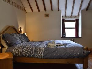 a bedroom with a bed with a blue comforter at Valley Cottage in Penmachno