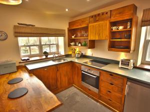 cocina con armarios de madera y mesa de madera en Gowan Bank Farm Cottage, en Staveley