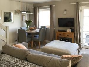 a living room with a couch and a table at Waters Edge Holiday Home in Beadnell