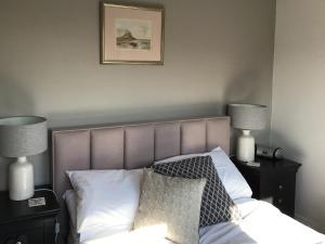 a bedroom with a bed with two night stands and two lamps at Waters Edge Holiday Home in Beadnell
