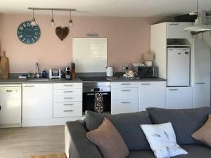 a living room with a couch and a kitchen at Waters Edge Holiday Home in Beadnell
