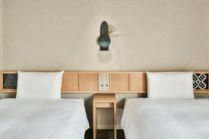 Ein Bett oder Betten in einem Zimmer der Unterkunft REF Matsuyama City Station by VESSEL HOTELS