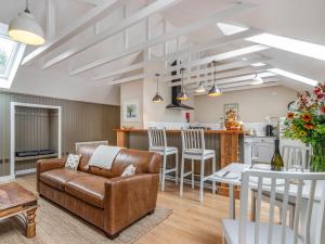 a living room and kitchen with a couch and a table at The Granary - Uk34899 in Dunira