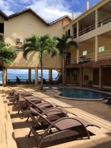 szereg krzeseł obok budynku z basenem w obiekcie Lalaguna Beach Club & Dive Centre w mieście Puerto Galera