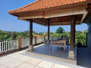 a pavilion with a bench and a table on a deck at Villa Sari Tagtag Bali in Sanur