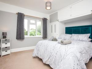 a bedroom with a large bed and a window at Devon Sands in Paignton