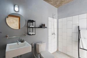 bagno con servizi igienici, lavandino e specchio di Ambara U6 Loft by Hombali a Canggu